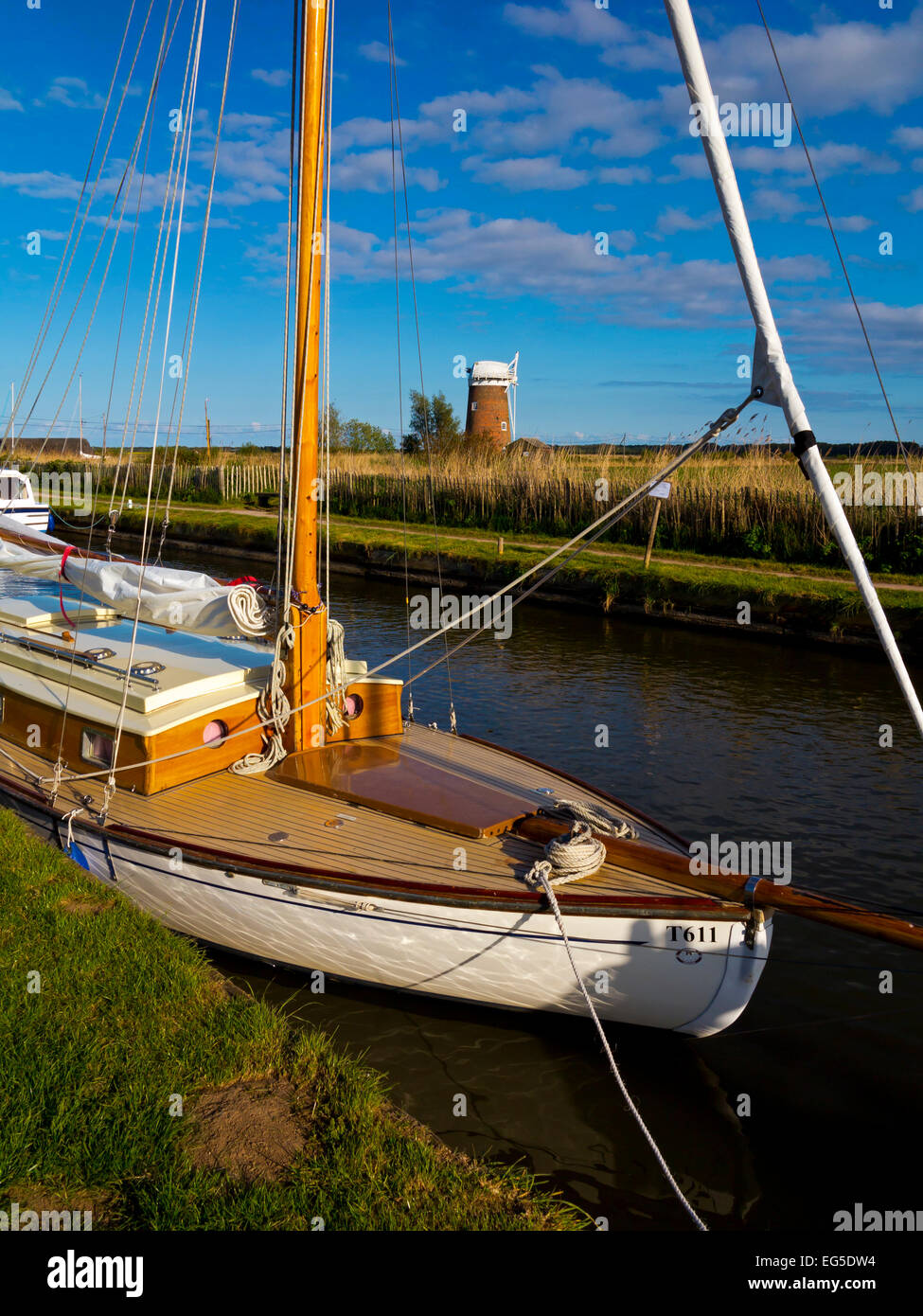 Voiliers traditionnels bateaux amarrés à Horsey simple dans les Norfolk Broads East Anglia Angleterre UK avec Horsey pompe éolienne en arrière-plan Banque D'Images