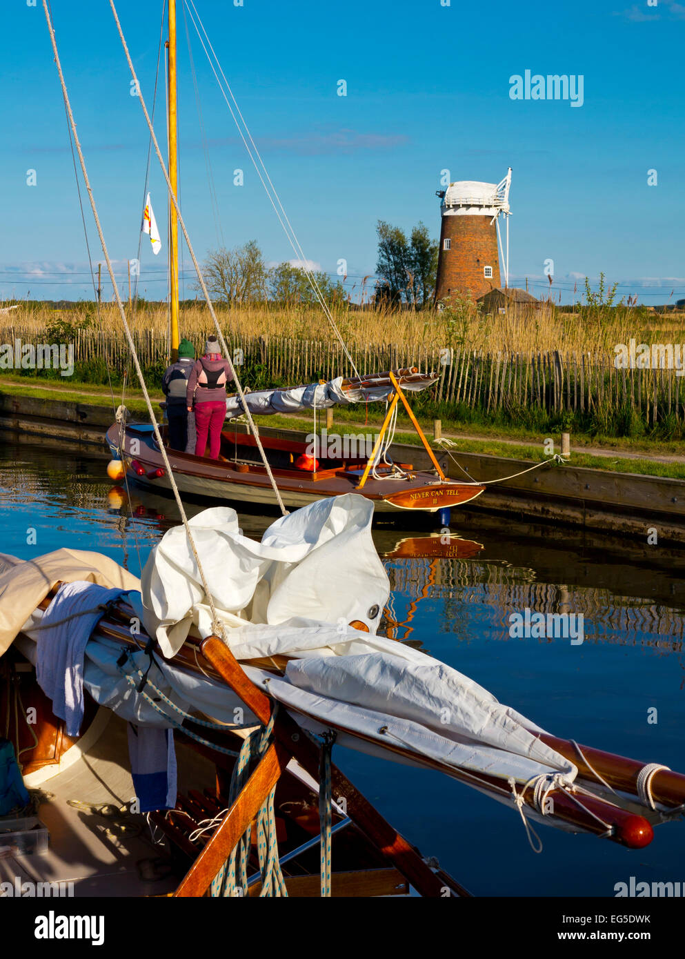 Voiliers traditionnels bateaux amarrés à Horsey simple dans les Norfolk Broads East Anglia Angleterre UK avec Horsey pompe éolienne en arrière-plan Banque D'Images