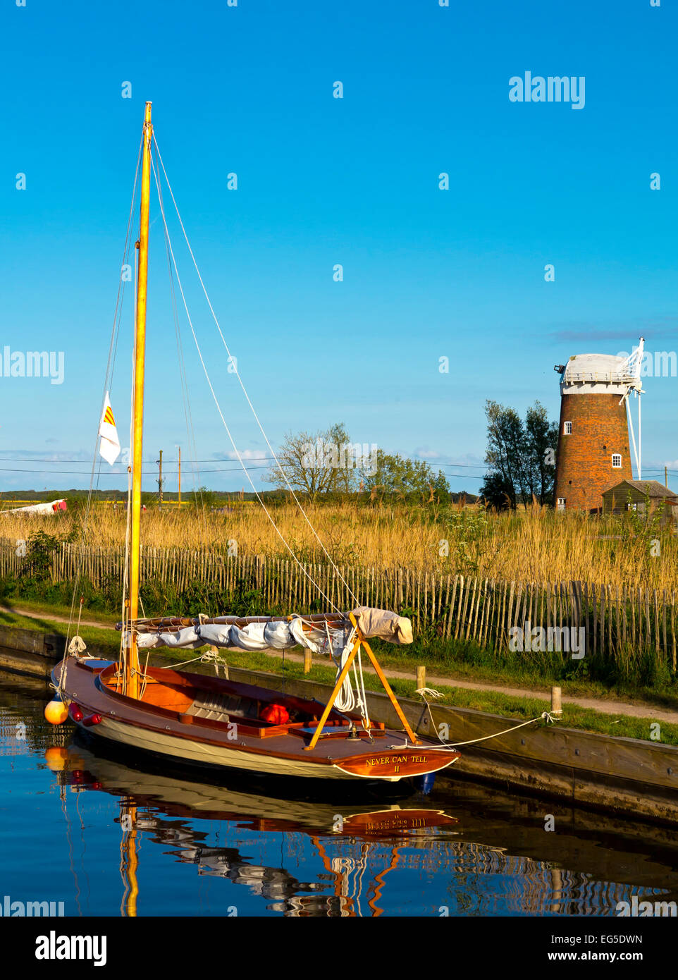 Bateau à voile traditionnel amarré à Horsey simple dans les Norfolk Broads East Anglia Angleterre UK avec Horsey pompe éolienne en arrière-plan Banque D'Images