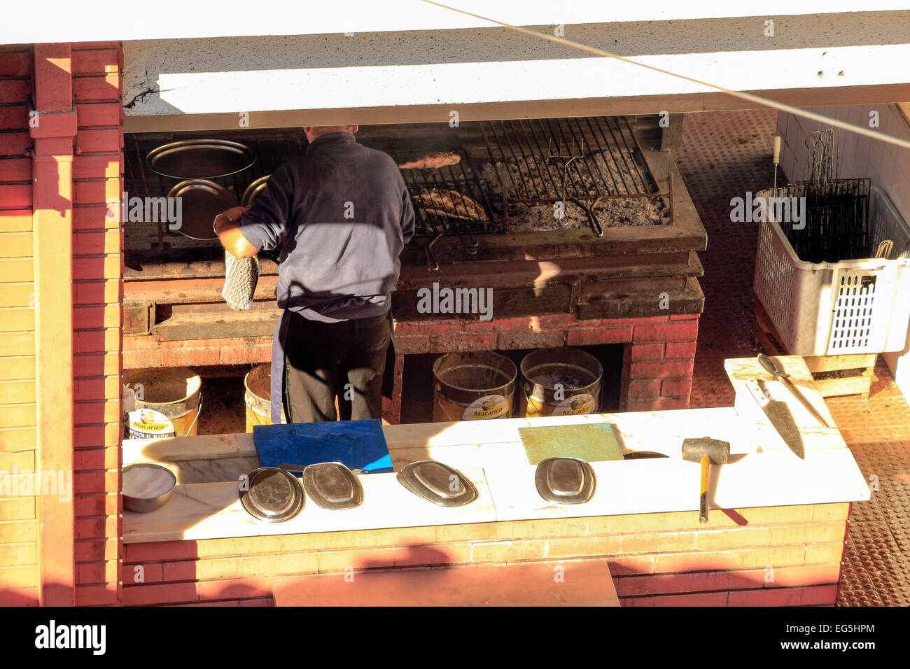 Un man grilling sardines fraîches, Portimao, Algarve, Portugal Banque D'Images