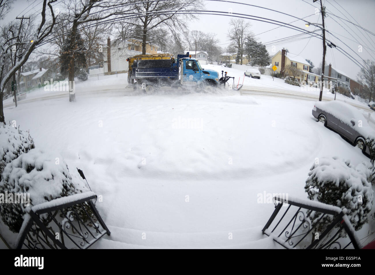 New York, USA. Feb 17, 2015. Un chasse-neige à partir de la ville de Hempstead, Long Island, charrues street comme la neige tombe de nouveau sur la rive sud, où les montants les plus élevés sont attendus dans la région, créer des conditions dangereuses au cours de la circulation du matin. Fisheye 180° Vue, vu de devant d'entrée de la maison de banlieue. La température est de 18 degrés Fahrenheit, et l'accumulation de neige de 3 à 5 pouces est prévu dans L.I., New York City, et à proximité des zones du nord-est. Météo d'hiver demeure en vigueur jusqu'à 12 heures de service météorologique national. Credit : Ann Parry/ZUMA/Alamy Fil Live News Banque D'Images