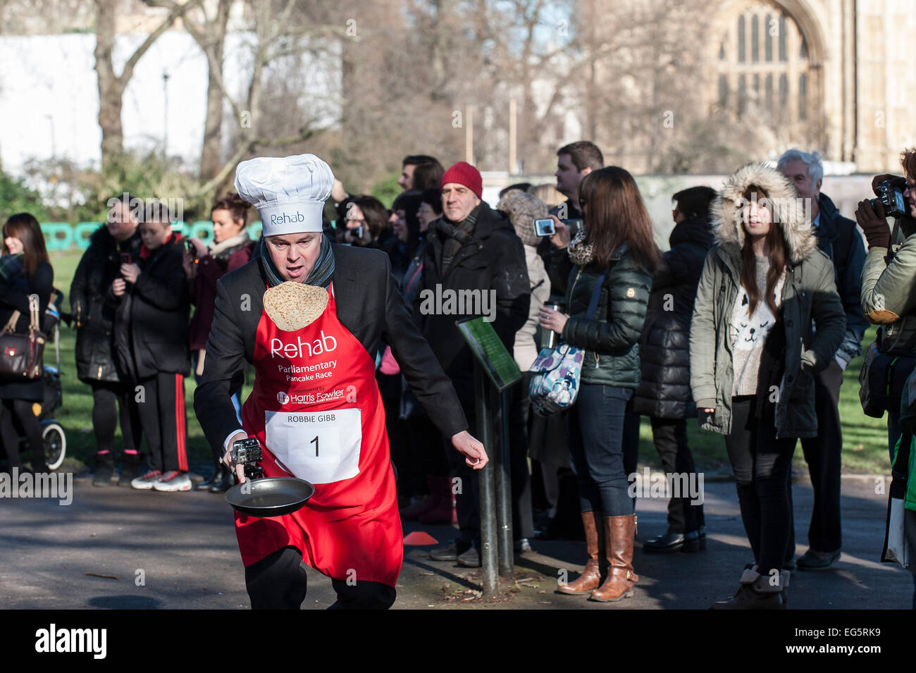 Londres, Royaume-Uni. 17 Février, 2015. Robbie Gibb, BBC rédactrice politique jetant son pancake pendant la course de crêpes parlementaire Rehab. Le concours annuel est parrainé par Harris Fowler, la blessure Procureurs et dispose de seigneurs, les députés et les membres du corps de presse parlementaire s'affrontent pour la course magnifique gobelet en étain. Credit : Gordon 1928/Alamy Live News Banque D'Images