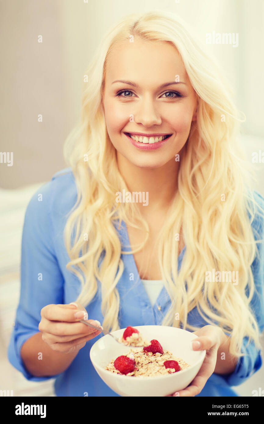 Femme souriante avec bol de céréales à déjeuner Banque D'Images