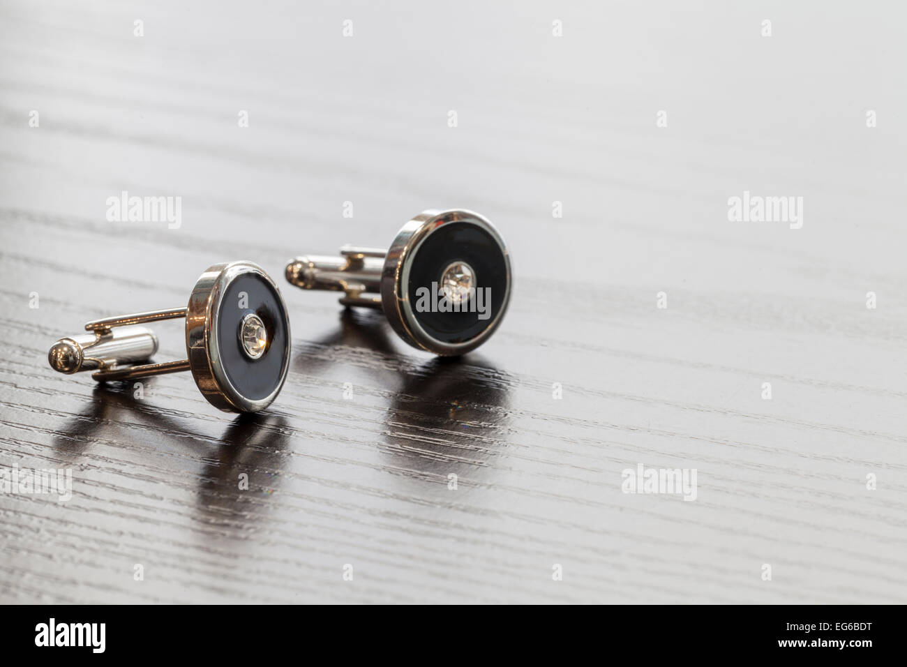 Argent cuff links sur table en bois close up Banque D'Images