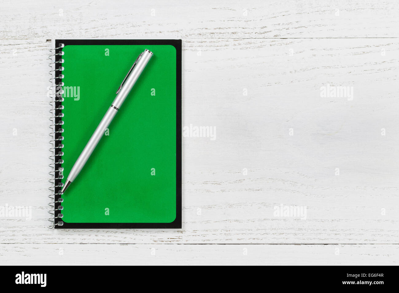 Spirale vert bloc-notes avec stylo sur le bureau. Banque D'Images