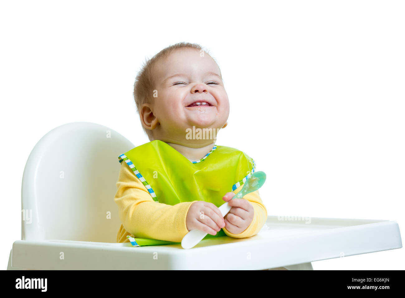 Funny bébé enfant assis dans une chaise haute avec une cuillère Banque D'Images