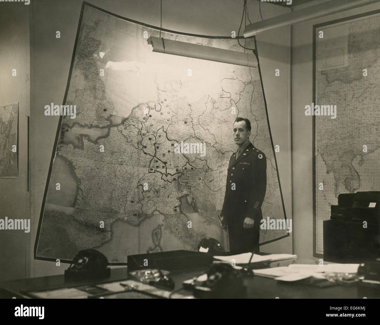 Salle des cartes de la Maison Blanche, ca. 1943. U.S. Army Signal Corps Al Cornelius se tient entre des cartes de la guerre du Pacifique et d'Europe Banque D'Images