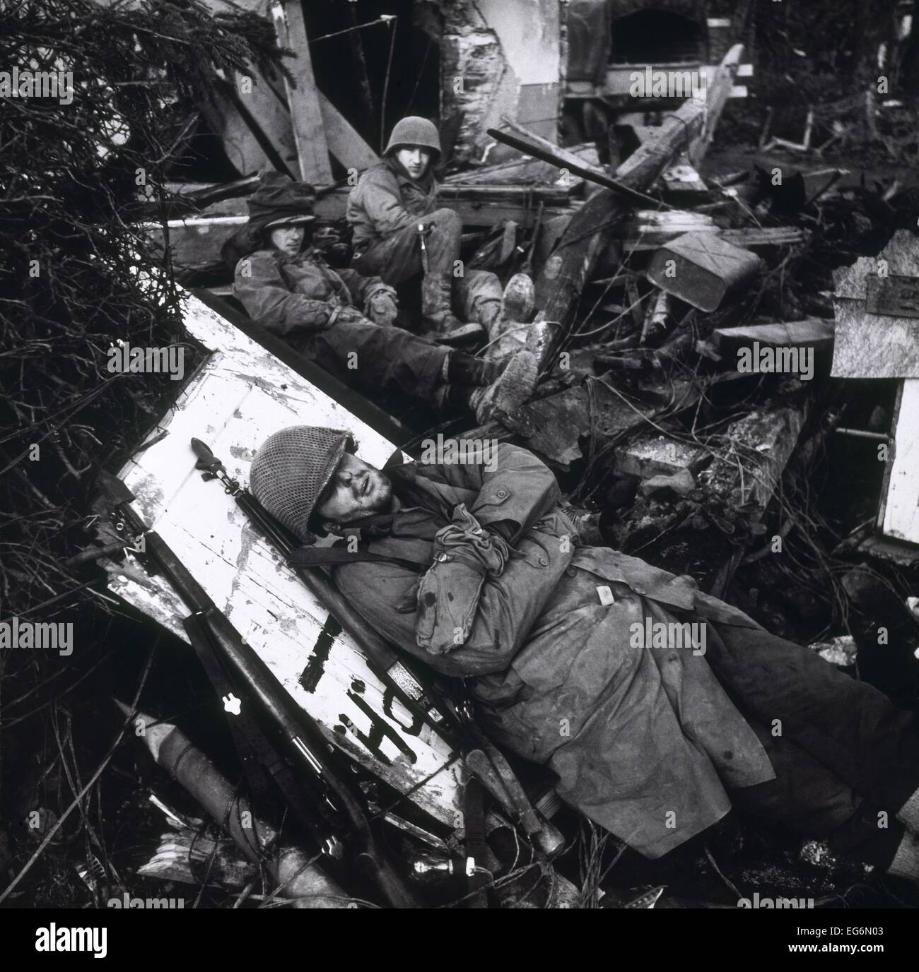 Des soldats américains se reposant au milieu des ruines de l'édifice, avec un GI allongé sur planche. Sur la ligne Siegfried, dans la vallée du Rhin en février. Banque D'Images