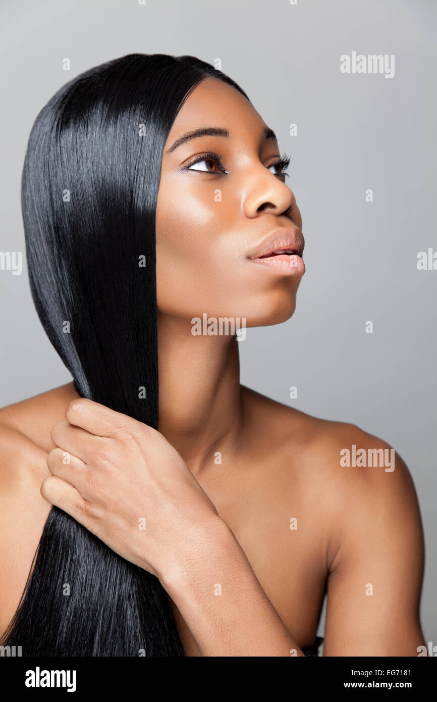 Profil d'une jeune beauté noire avec longue ligne droite et des cheveux brillants Banque D'Images