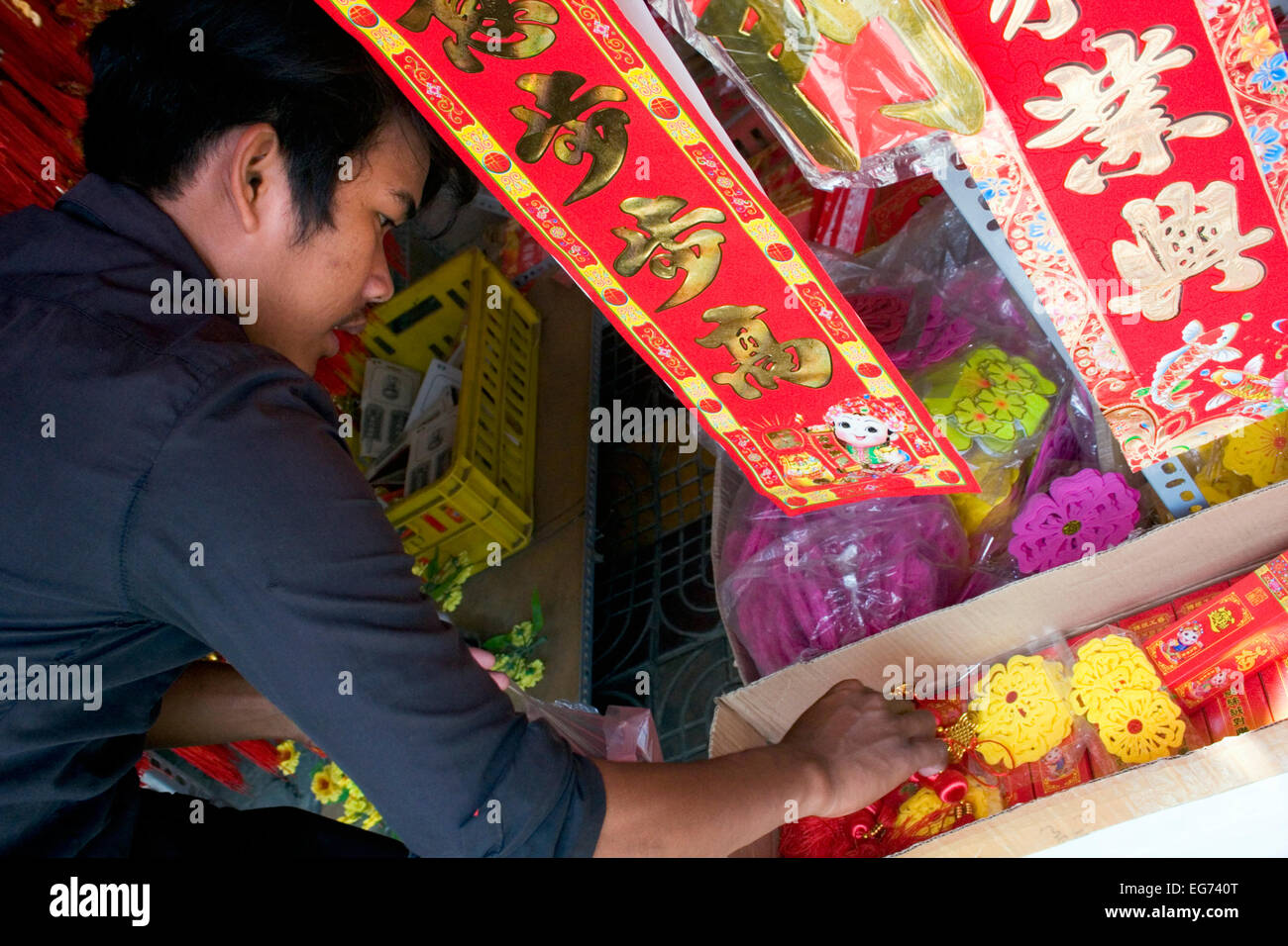 Un homme travaille dans un magasin vendant des articles traditionnels pour le Nouvel An chinois à Phnom Penh, Cambodge. Banque D'Images