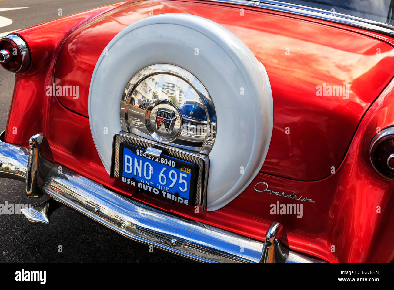 American Vintage automobile Ford garée à Miami avec la réflexion d'une autre voiture d'époque dans le chrome de la roue de secours Banque D'Images