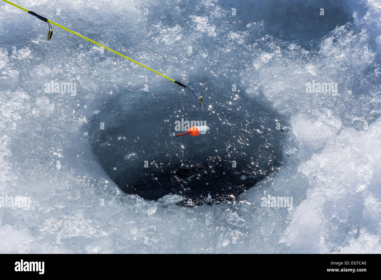 La pêche sur glace pour les crapets dans un trou sur un lac dans le centre de Michigan, USA Banque D'Images