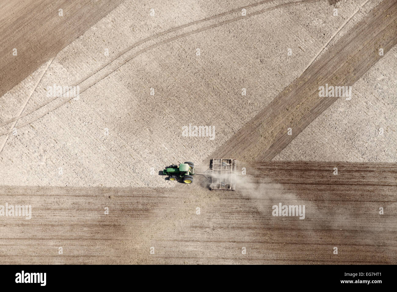 Une vue aérienne de la machinerie agricole labourant sous un champ de blé en vue de la prochaine année. Banque D'Images