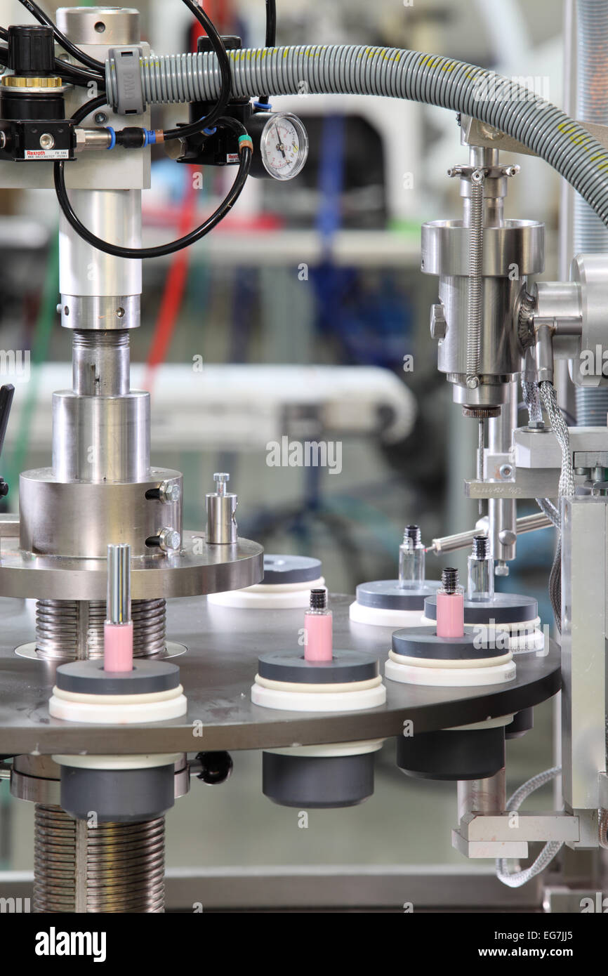 Le remplissage des flacons d'une machine dans une usine de produits cosmétiques. Banque D'Images