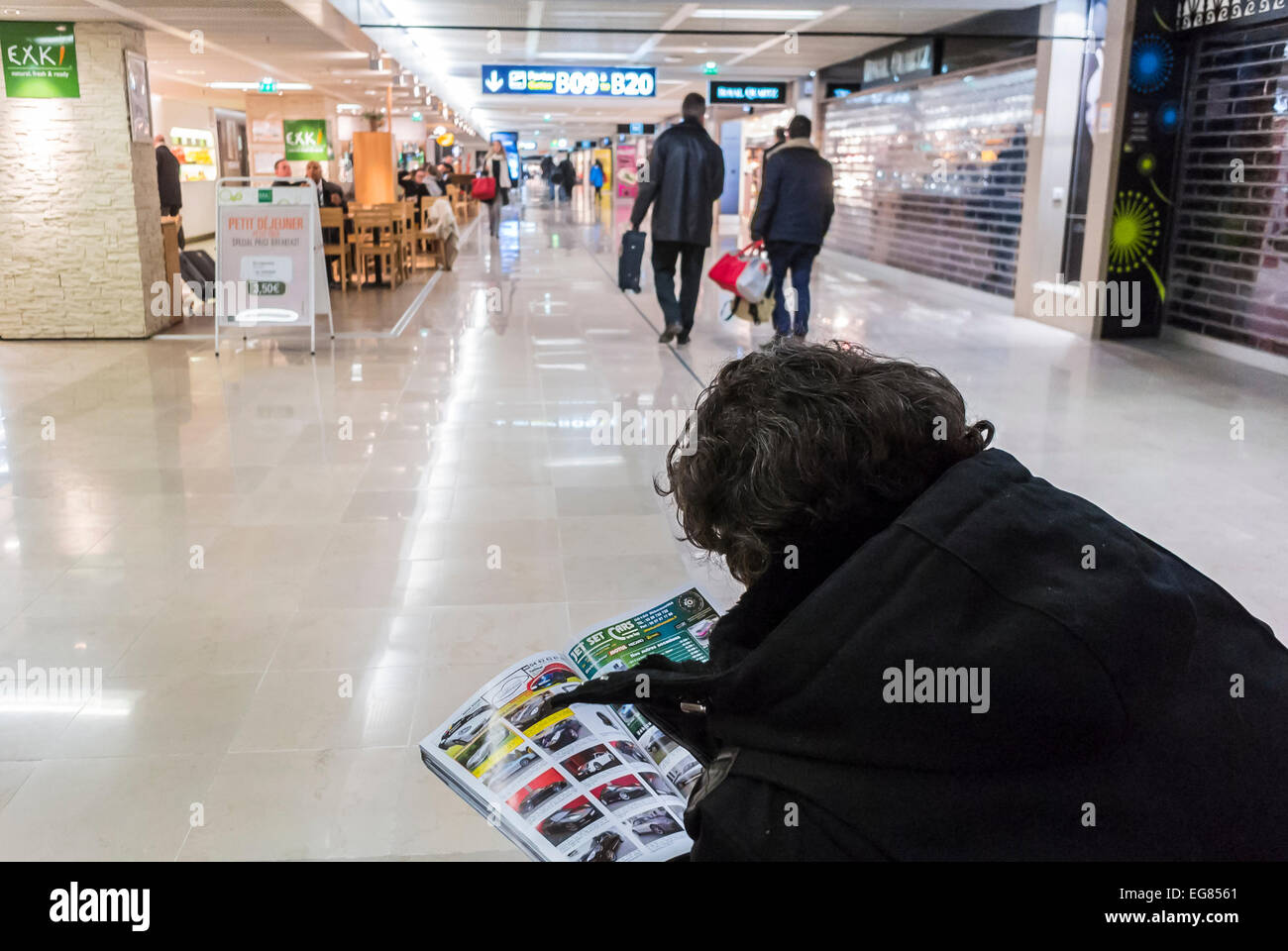 Paris, France, vue, foule nombreuse, passagers en attente dans le hall, aéroport d'Orly, Man Reading car Magazine de derrière Banque D'Images