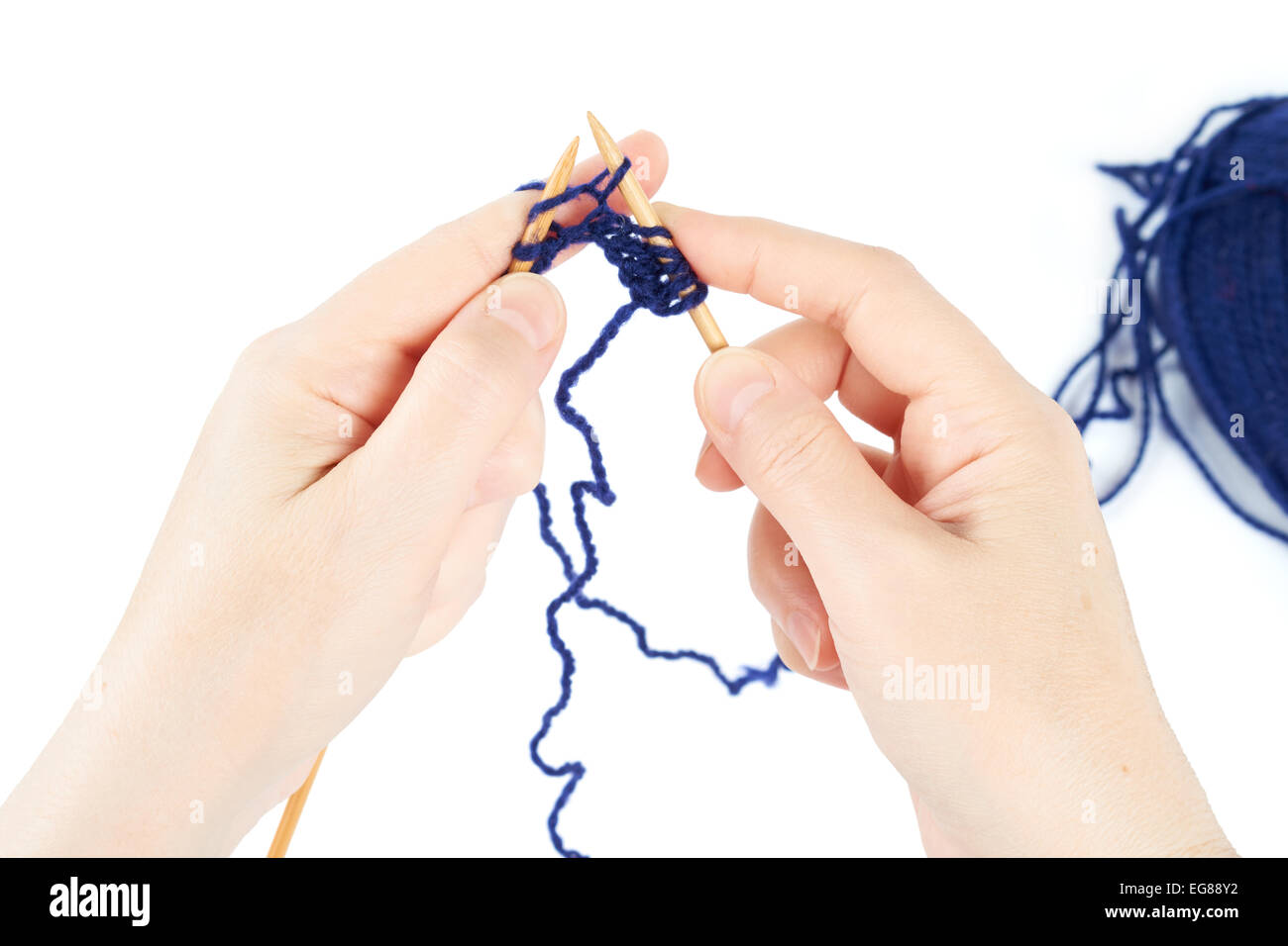 Le tricot commence. Paire de mains de la femme et des aiguilles à tricoter isolated on white Banque D'Images