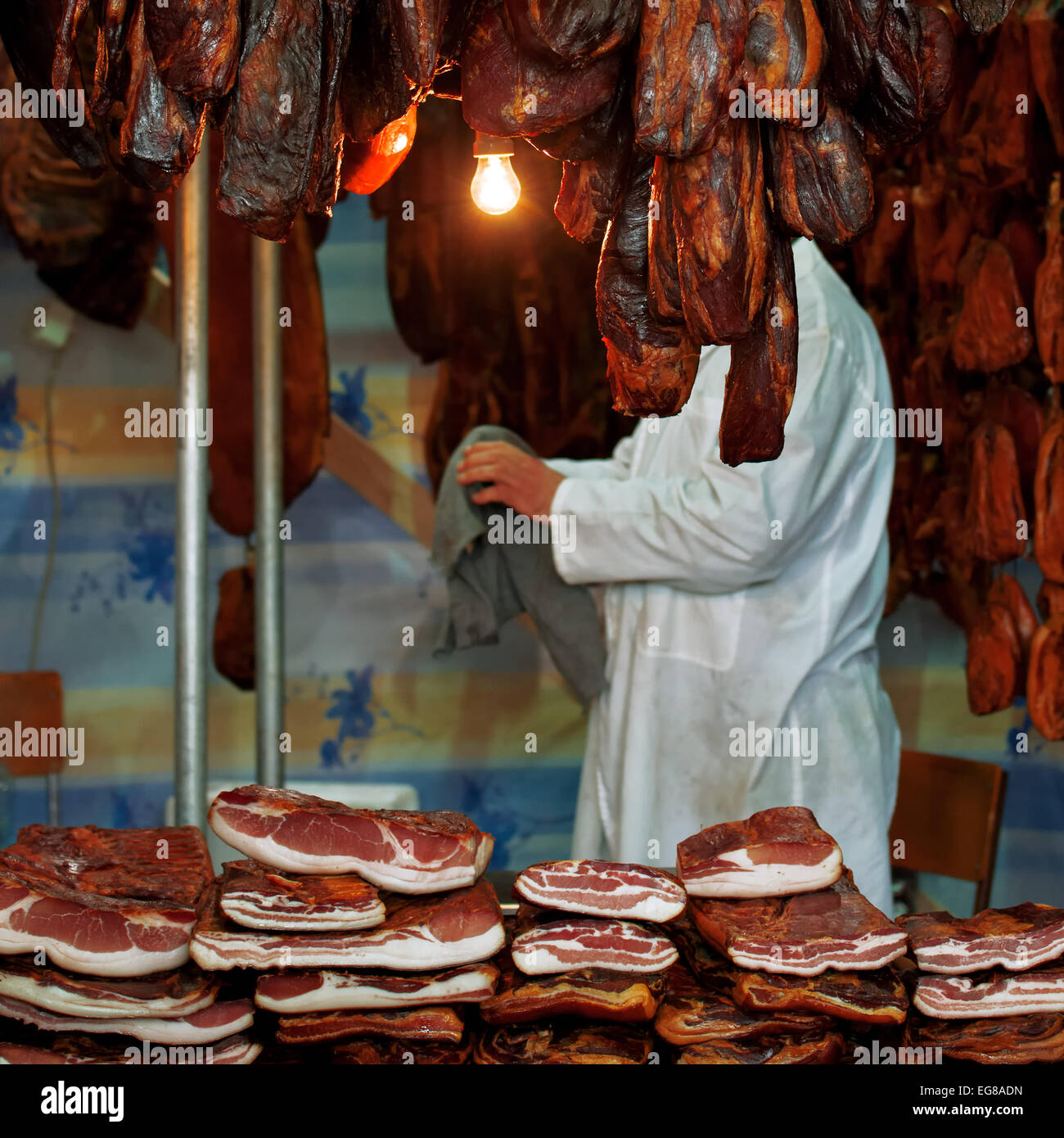 Boucher à la viande de porc juste avec des piles de lard fumé et d'autres viandes de porc. Banque D'Images