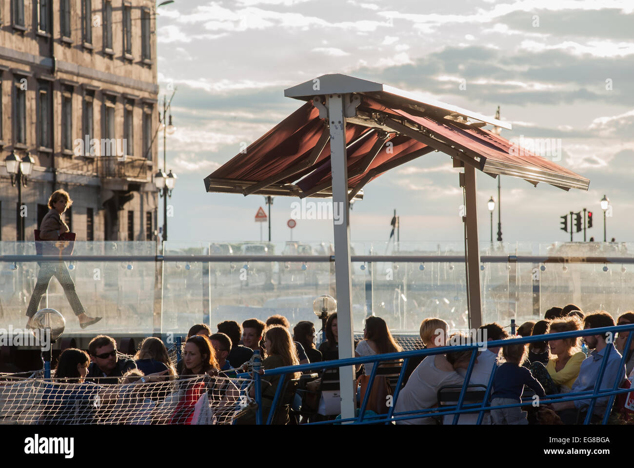Les gens apprécient la dernière du soleil en prenant un verre dans un bar sur le Gran Canale à Trieste, Italie Banque D'Images