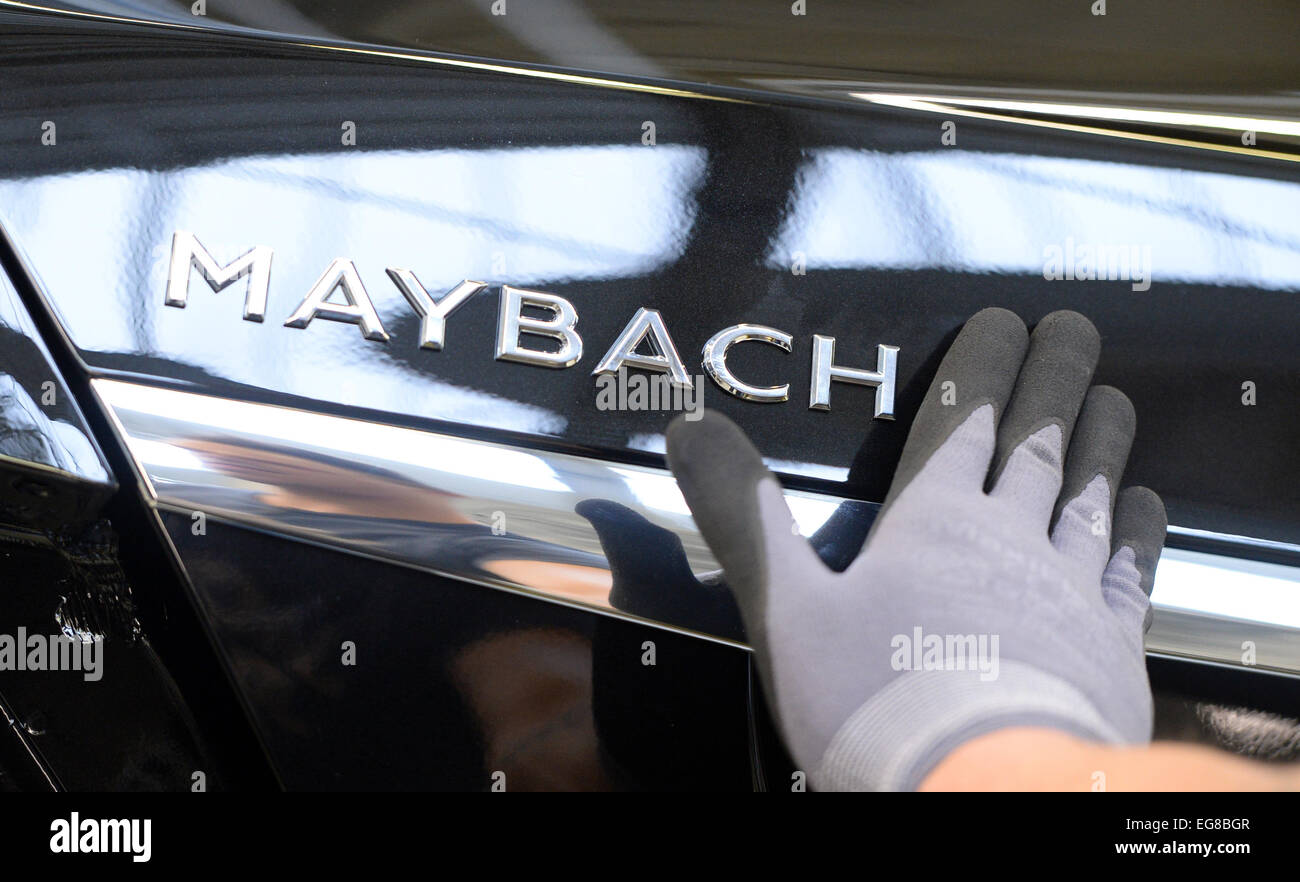 Les membres du personnel d'une attache de l'emblème de la voiture de luxe Mercedes Maybach modèle sur le capot d'une Mercedes Maybach voiture à l'usine d'assemblage à Sindelfingen, Allemagne, 28 janvier 2015. Photo : Bernd Weissbrod/dpa Banque D'Images