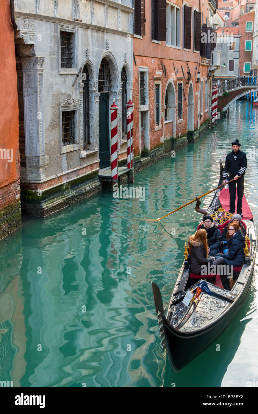 Avec gondole gondolier et touristes dans un étroit canal d'eau, Venise, Vénétie, Italie Banque D'Images