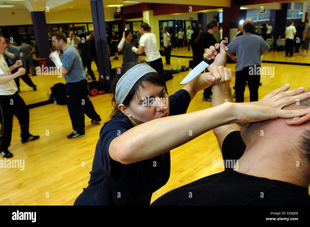 Photos de Krav Maga : un mode d'auto défense pratiqué et rendue populaire par l'armée israélienne basée sur un combo de Judo et Ju-jitsu , Karaté Kung Fu - dark haired girl rôles swaps avec formateur Mike démontrant un certain nombre d'attaque/situations de légitime défense - plus des professionnels et en particulier les femmes prennent ces sortes de classes peut-être en réponse à une augmentation de la violence physique sur les rues de Londres lieu de tournage 'Fitness First' London W1 20 mai 2007 publié le 11 juin 2007 commission le london lite formateur photo Mike Kapsalis Mike et étudiants www.kravmagalon parution modèle Banque D'Images