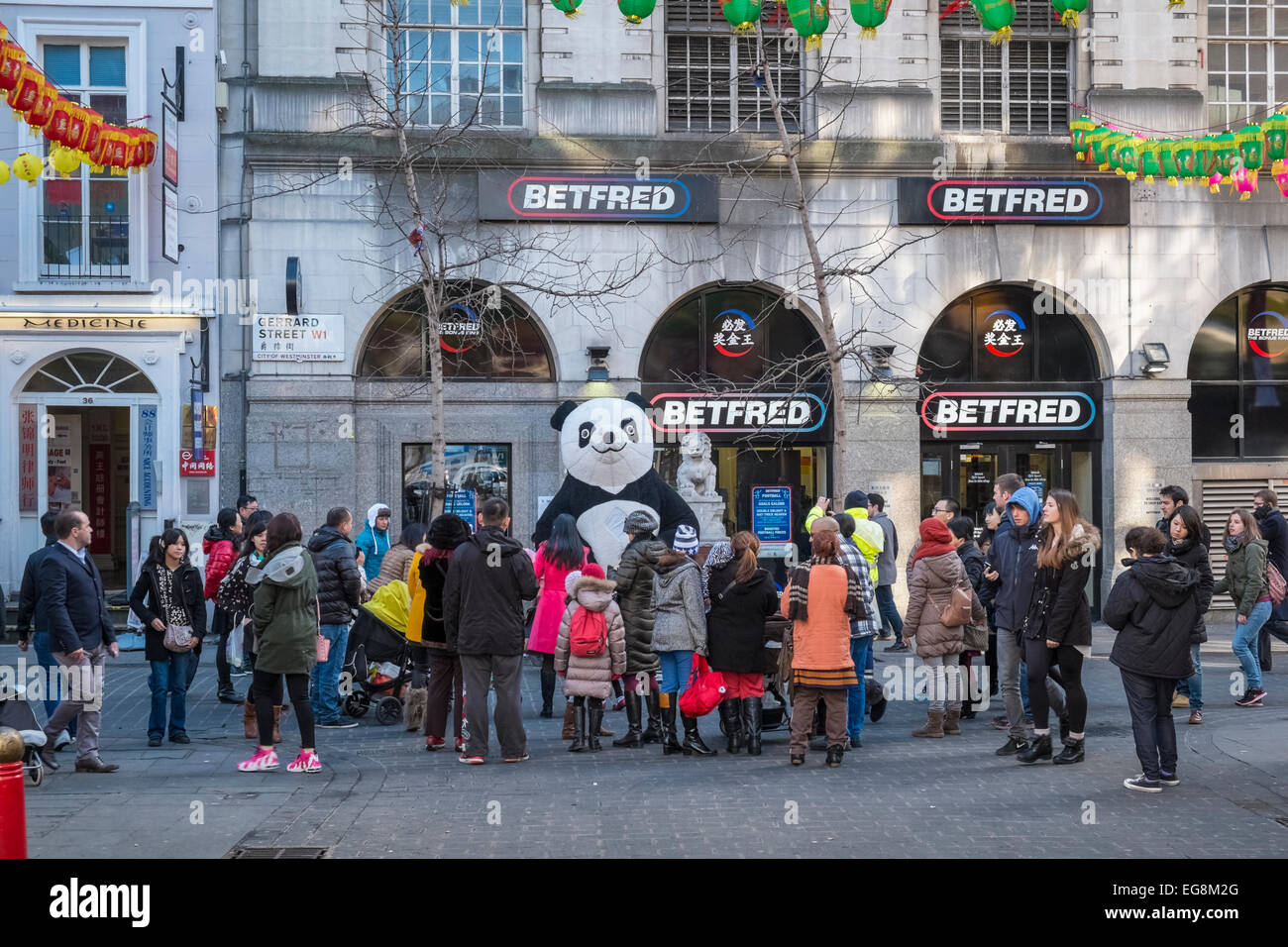 Personnes et un 'grand panda' sur Gerrard Street, Chinatown, Londres W1, pour le nouvel an chinois 2015. Banque D'Images