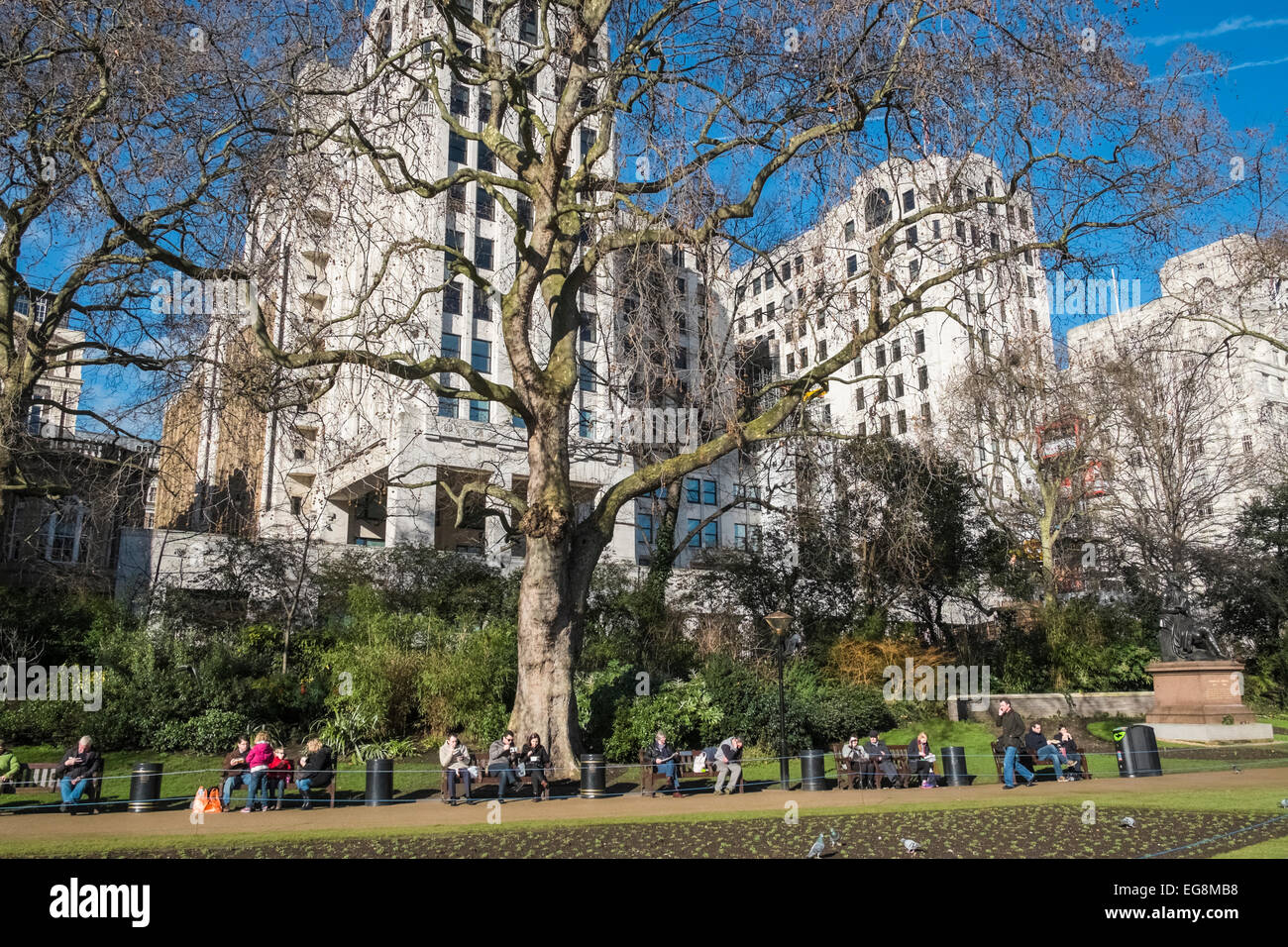 Des gens assis et agréable en hiver soleil, Victoria Embankment Gardens, London, UK Banque D'Images