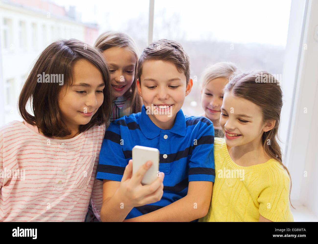 Groupe d'écoliers en tenant avec smartphone selfies Banque D'Images