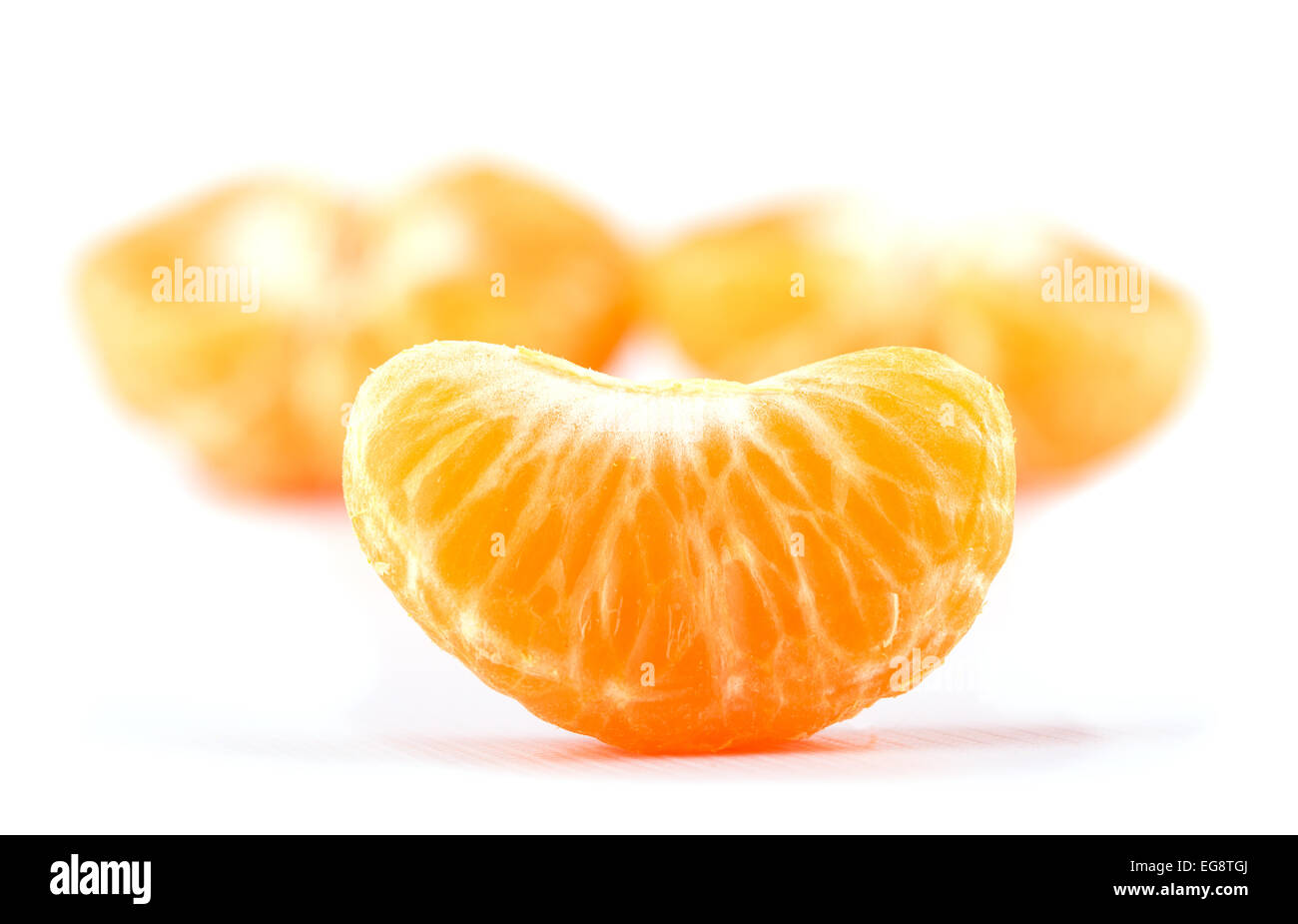 Tranche de clémentine, orange, avec deux moitiés sur l'arrière-plan, on white Banque D'Images