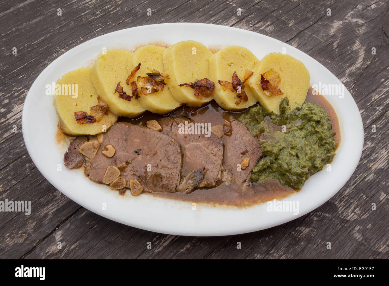 Une cuisine traditionnelle tchèque ou allemand (nourriture), boeuf aux épinards et raviolis préparés sur l'ail, servi dans un pub rustique (village) Banque D'Images