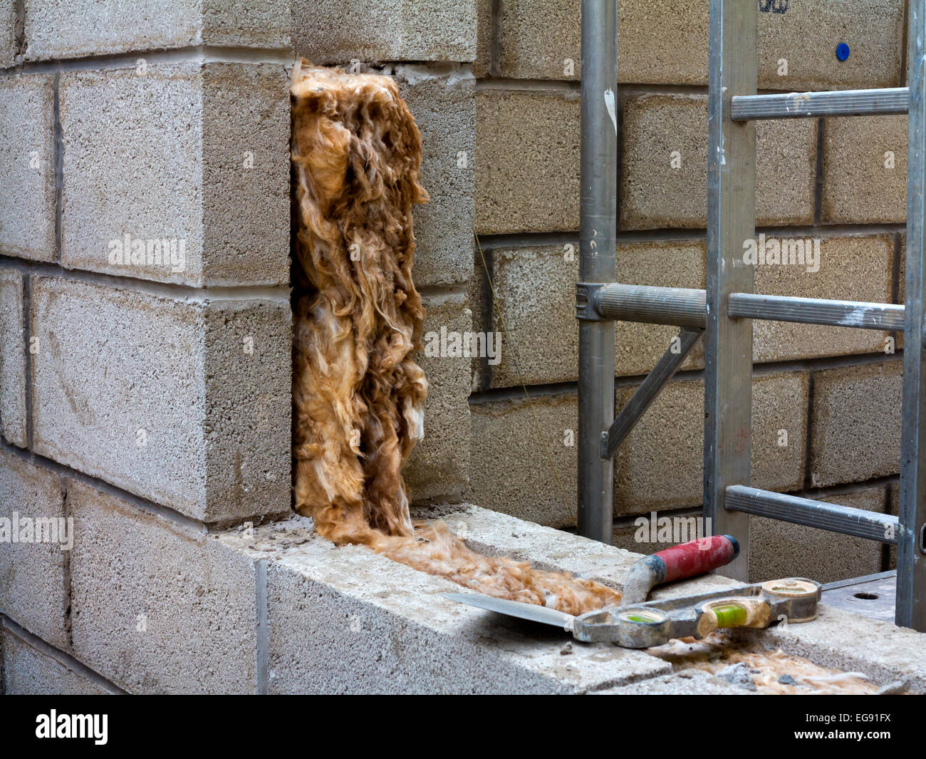 Extension maison en construction avec un matériau isolant visible dans les cavités entre les deux murs en blocs de Breeze pour fournir de la chaleur Banque D'Images