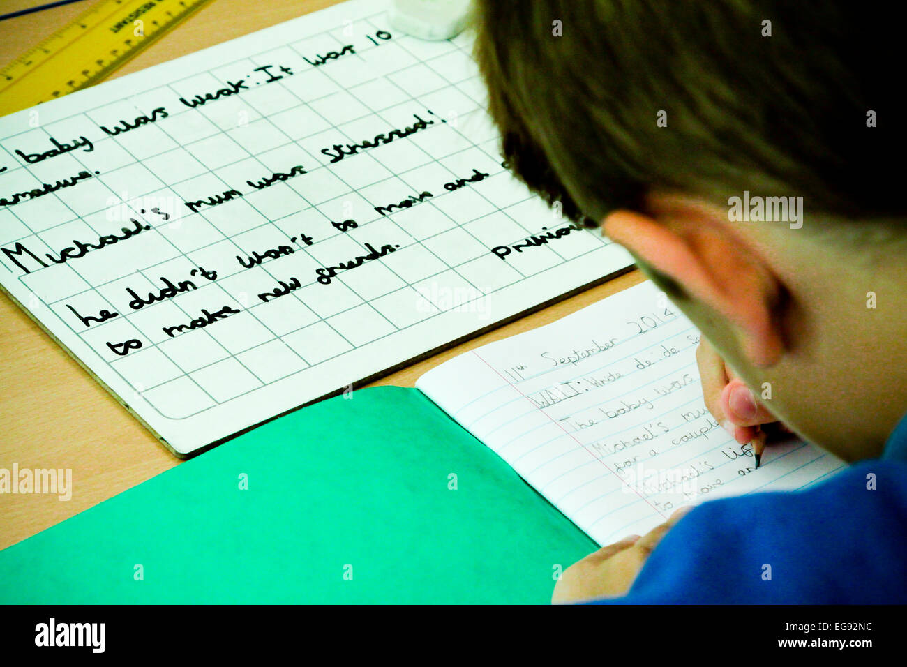 École primaire écrit avec un crayon pendant une leçon Banque D'Images
