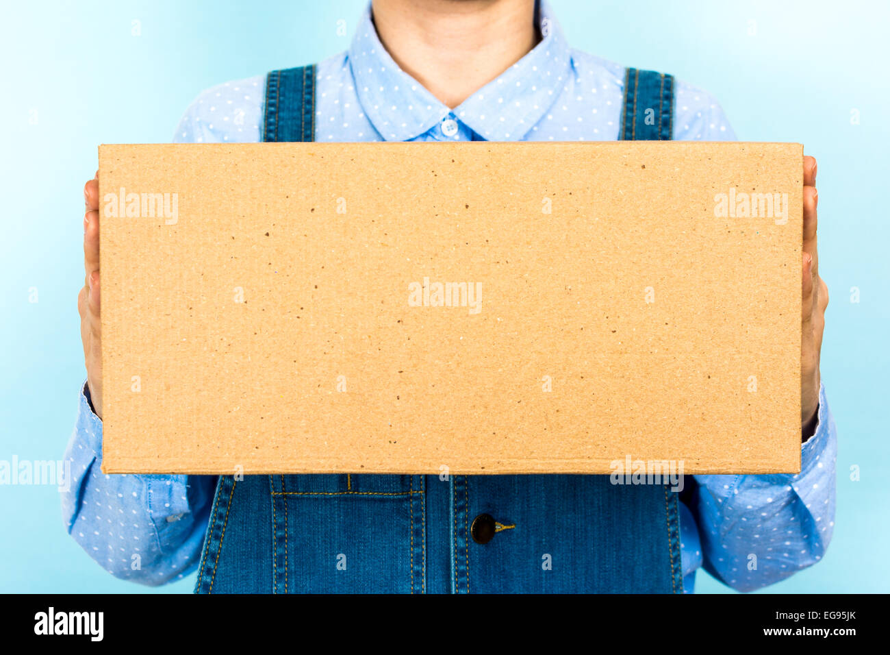 Femme tenant une boîte vide, carton, vue de face. Banque D'Images