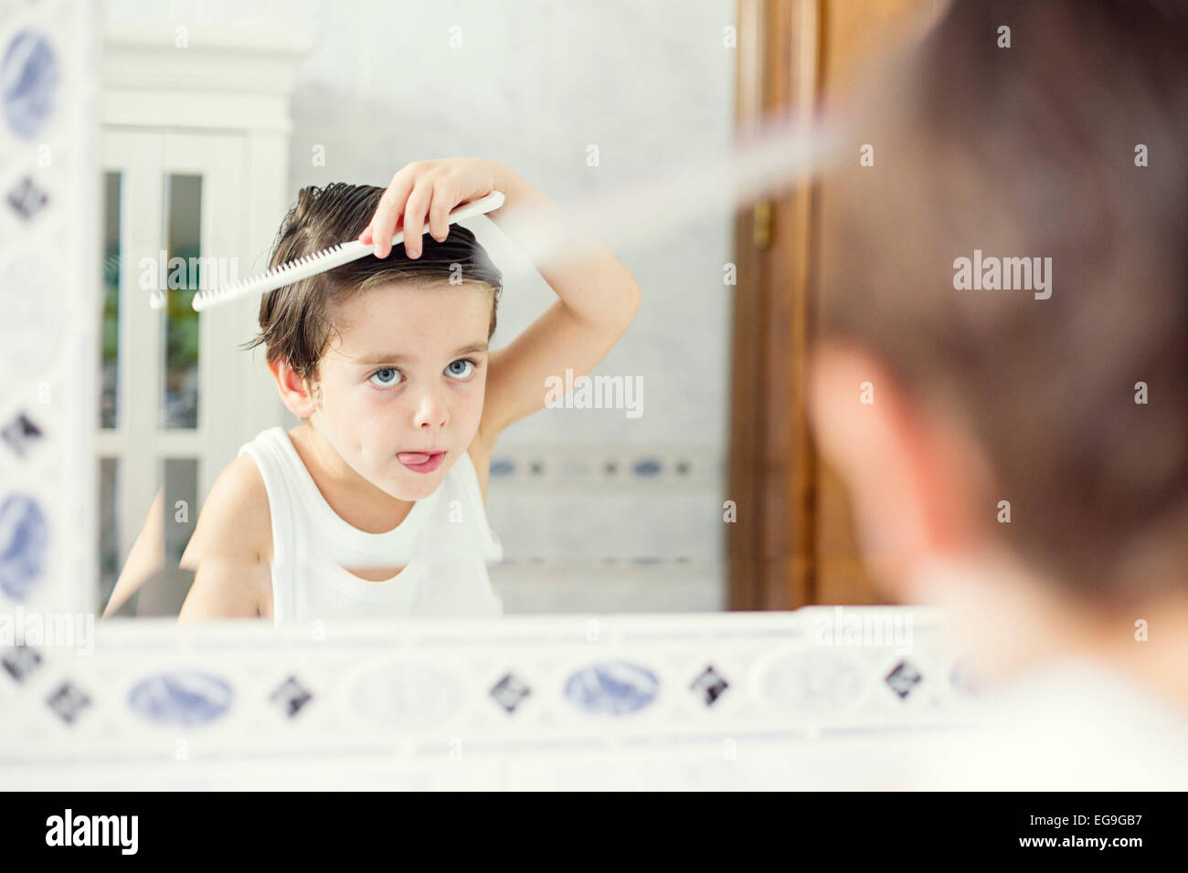 garçon de 10 ans dans un coiffeur après une coupe de cheveux à la mode  devant un miroir.Un petit enfant dans un salon de beauté regarde la caméra  poser Photo Stock 