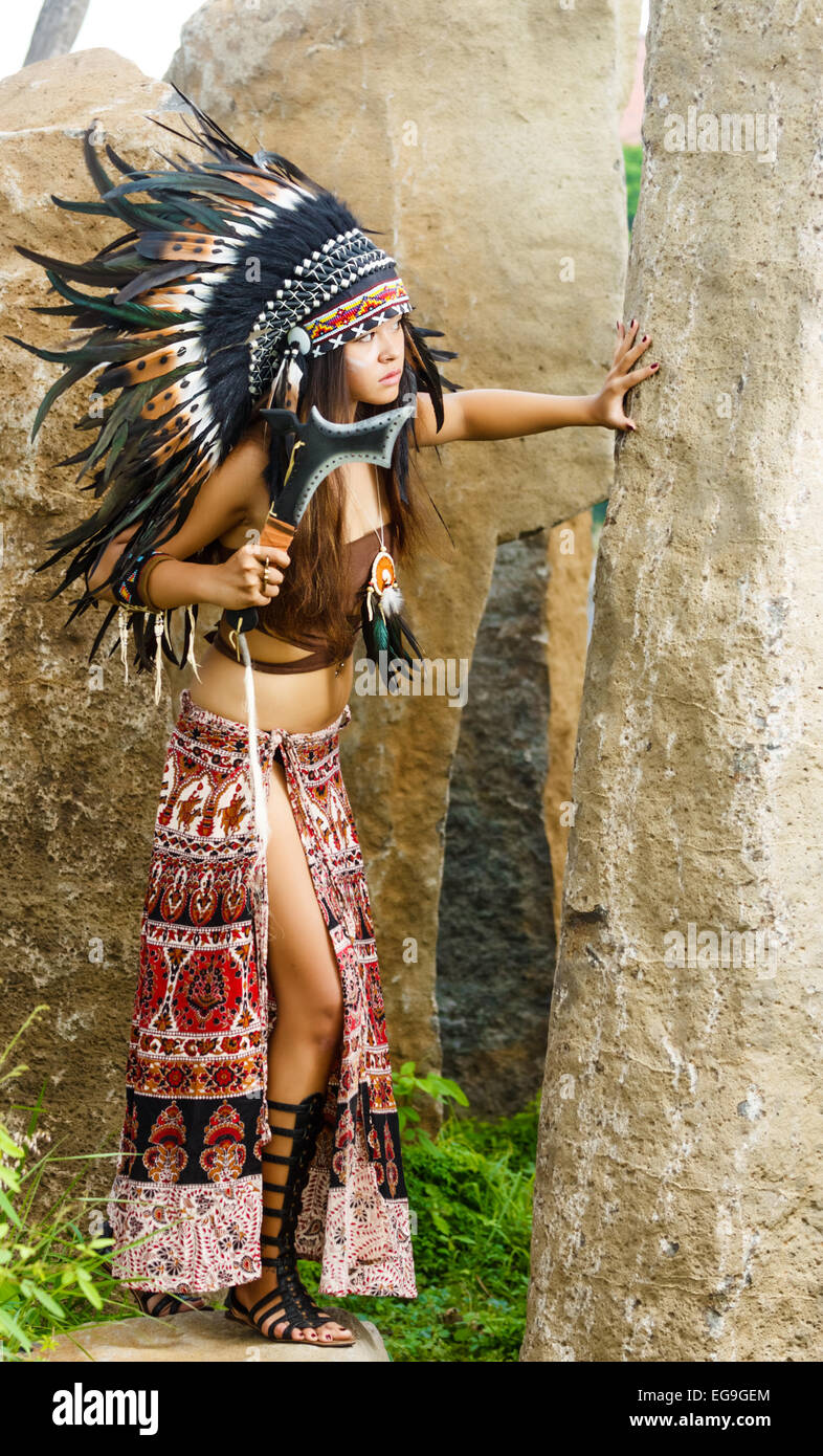 Native American, les Indiens en costume traditionnel, debout avec ax dans la jupe rouge. Banque D'Images