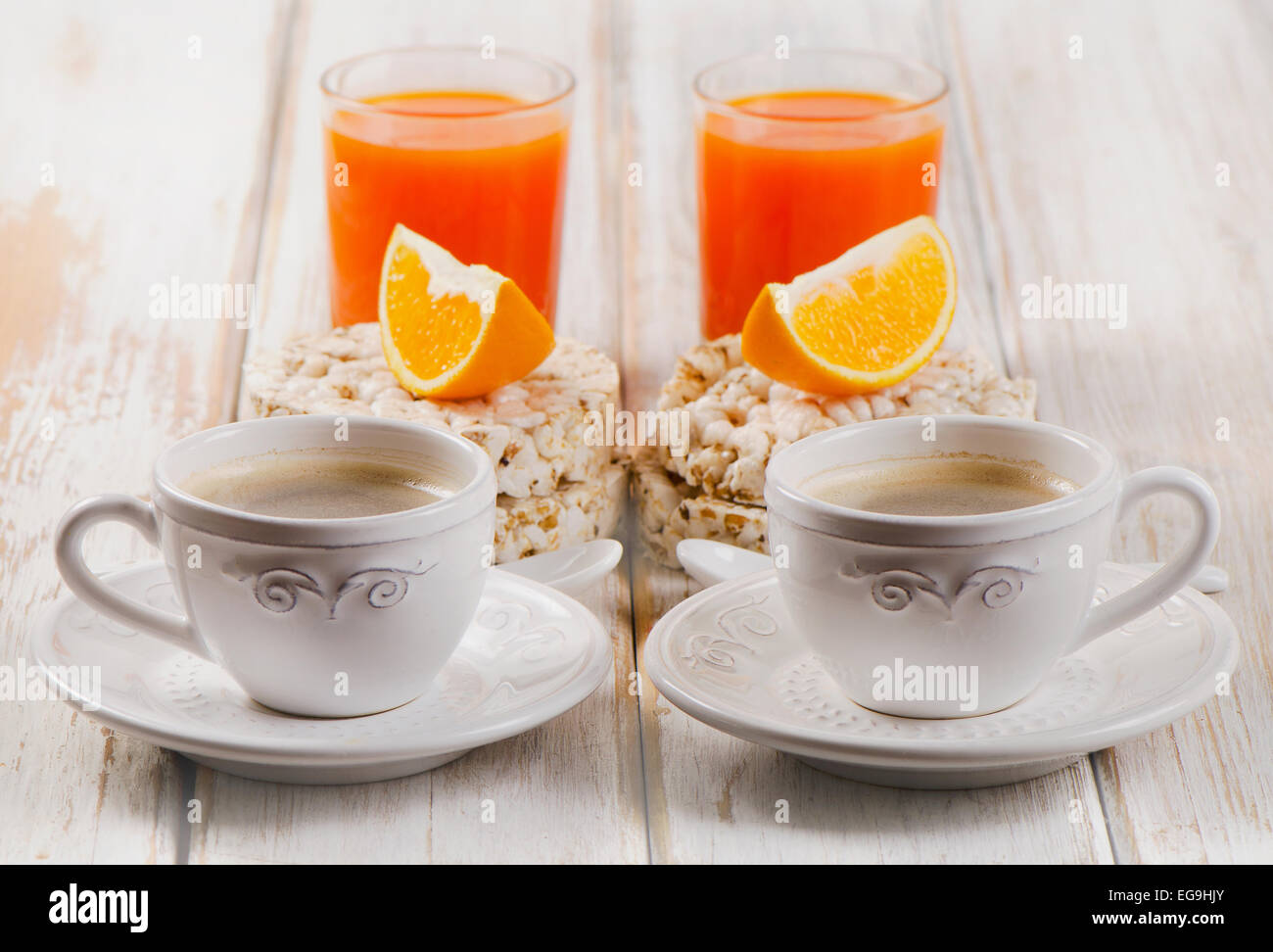 Le petit-déjeuner avec deux tasse de café, jus d'orange sur une table en bois blanc. Banque D'Images