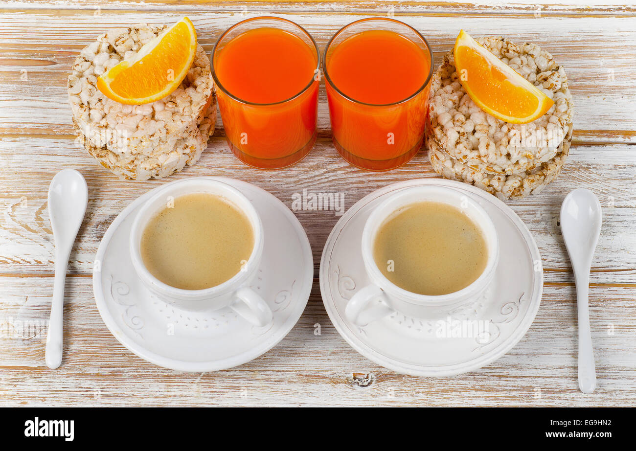 Petit-déjeuner sain avec deux tasses de café sur une table en bois blanc. Banque D'Images