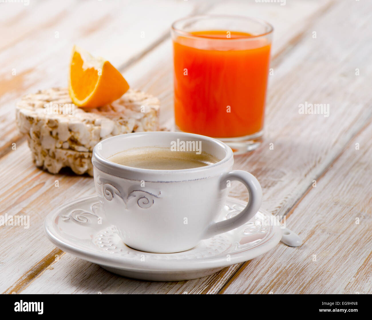 Tasse à café, jus d'orange sur une table en bois blanc. Banque D'Images