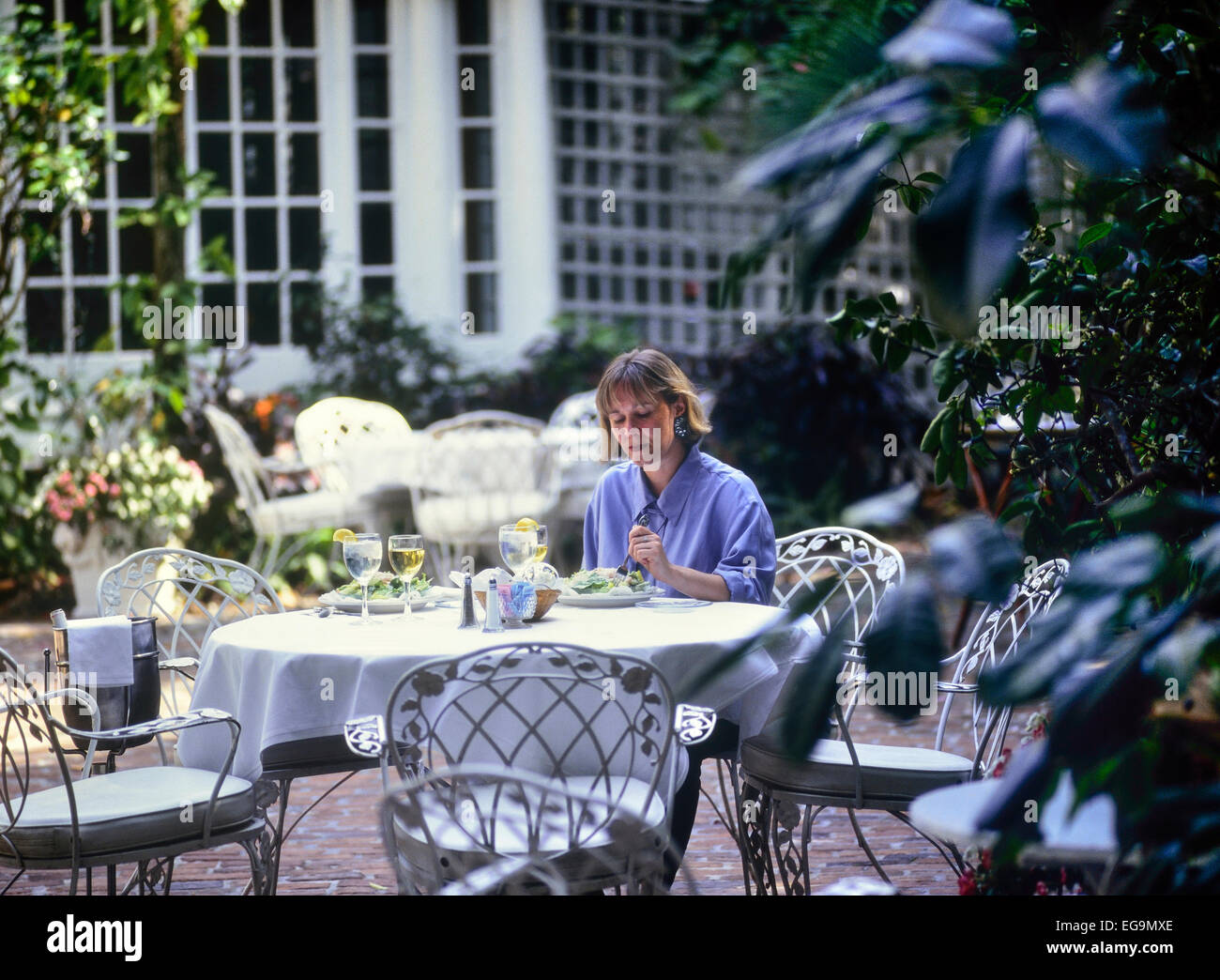 Woman eating lunch dans un restaurant Courtyard Banque D'Images