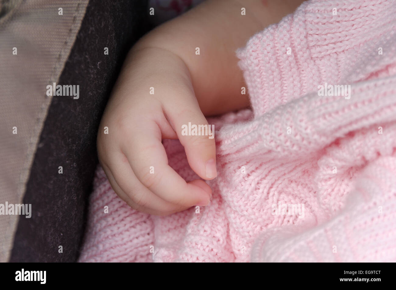 Main d'un bébé avec une couverture de laine rose Banque D'Images