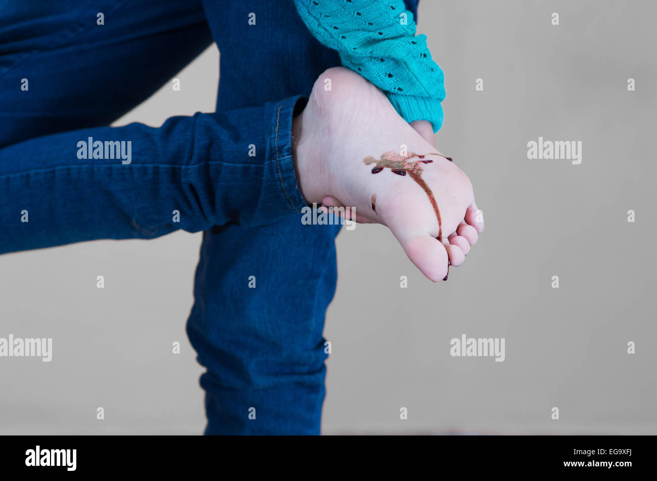 Jeune fille sang sur la plante de son pied Banque D'Images