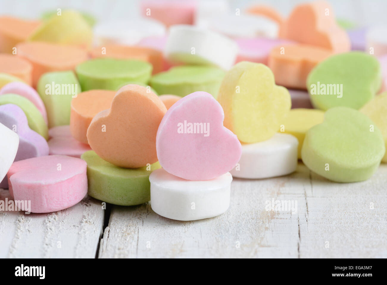 Libre d'un groupe de bonbons coeurs de Saint-valentin pastel sur une table en bois blanc rustique. Format horizontal. Banque D'Images