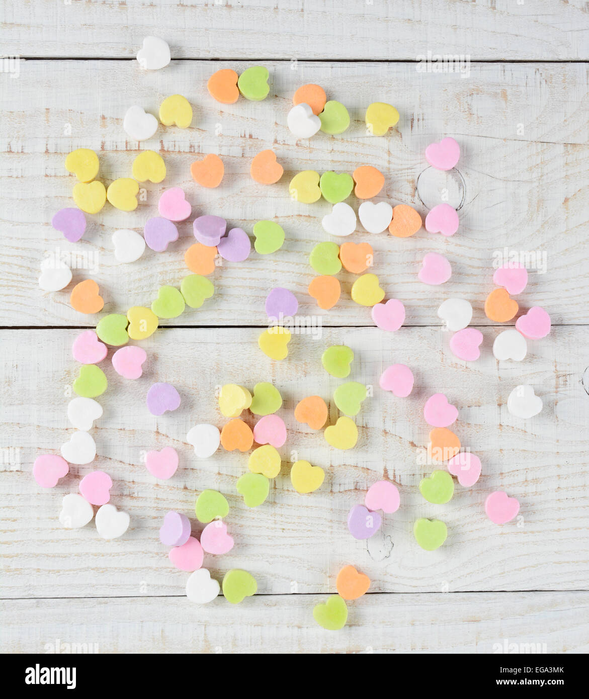 Un groupe de bonbons coeur saint Valentin dispersés de manière aléatoire sur une table en bois blanc rustique. Tourné en frais généraux square fo Banque D'Images