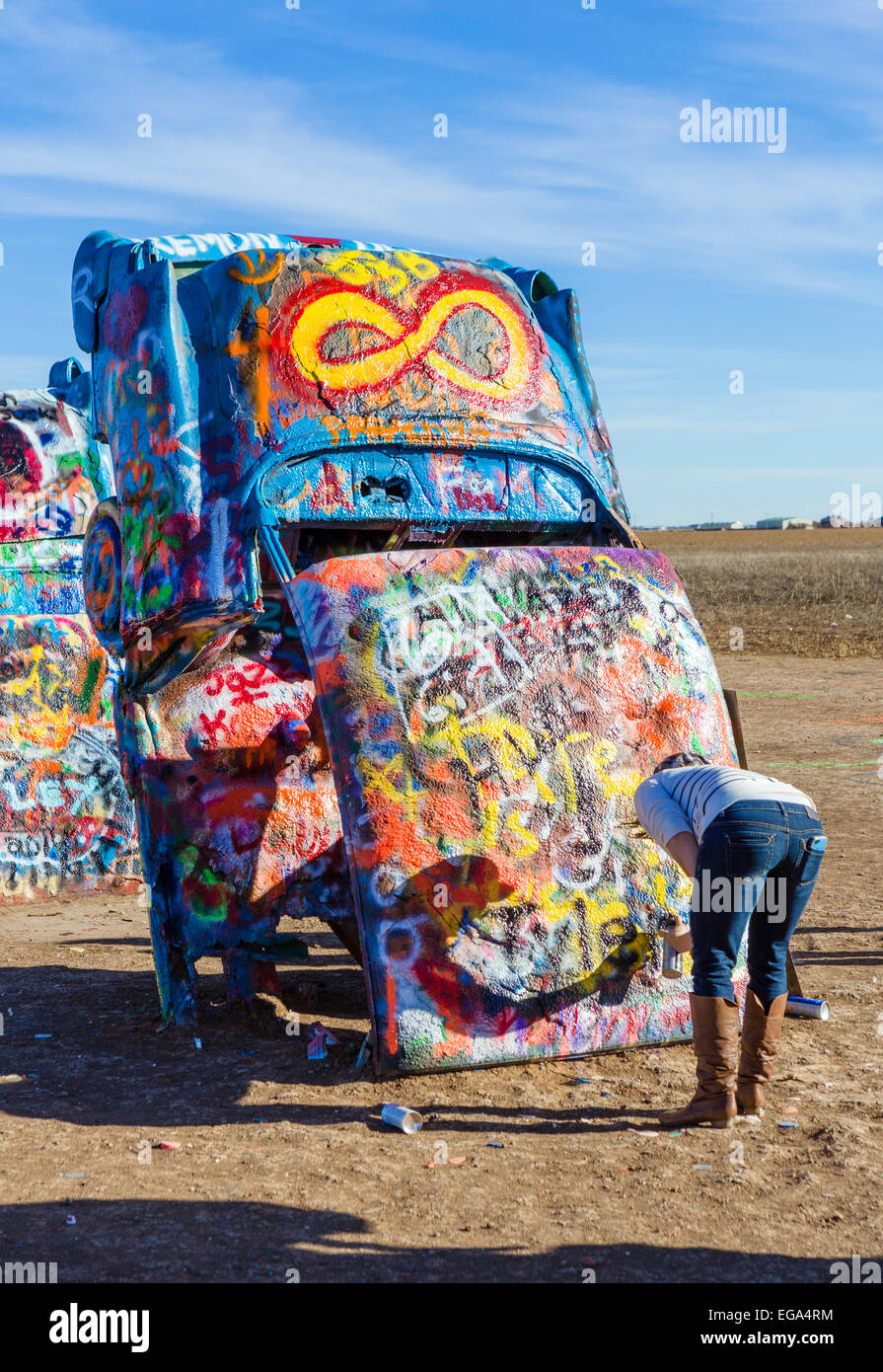Jeune femme peinture par pulvérisation d'une voiture à la Cadillac Ranch, une installation d'art public juste à l'extérieur de Amarillo, Texas, USA Banque D'Images
