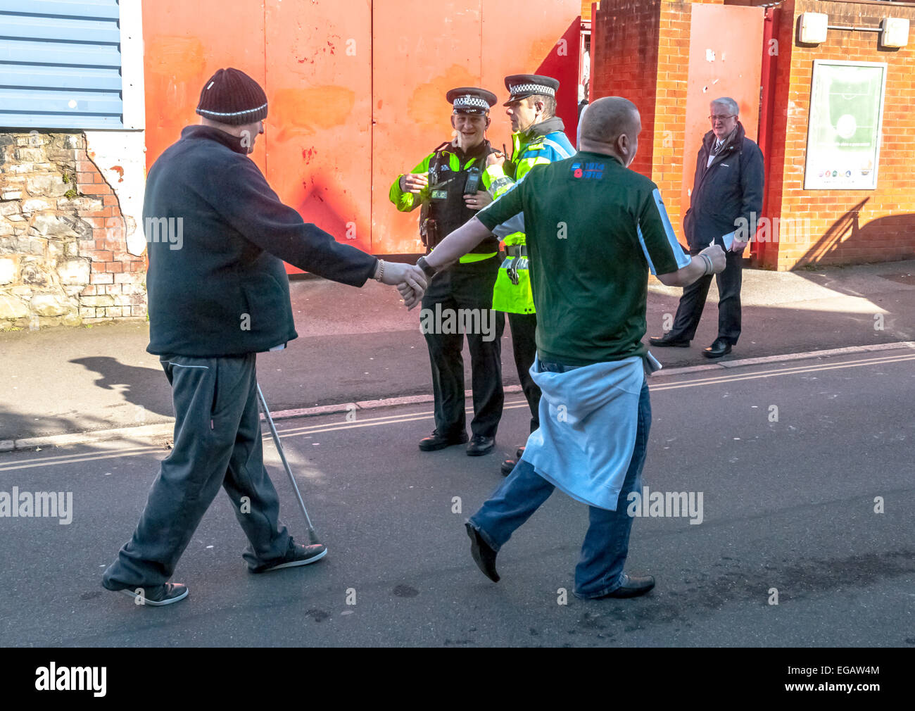 Plymouth Argyle mène un homme diabled partisan dans le terrain de football pendant l'opération de police pour prévenir la violence au football Ligue 2 le match de football entre Exeter City FC et Plymouth Argyle FC le 21 février 2015, à Exeter, Devon, UK Banque D'Images