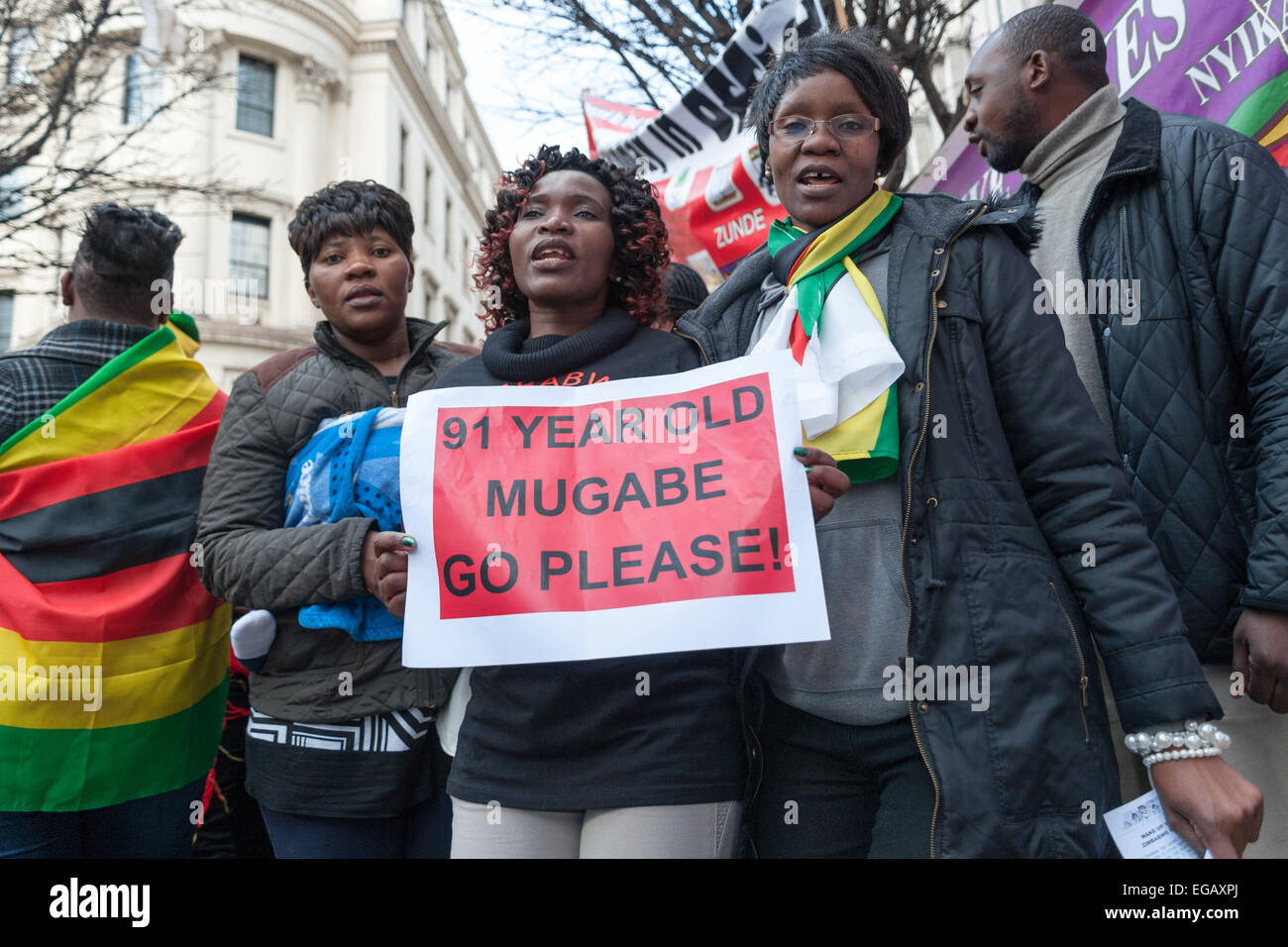 Londres, Royaume-Uni. 21 Février, 2015. Les activistes de l'extérieur de l'Ambassade du Zimbabwe dansent et chantent pour protester contre Mugabe pour son 91e anniversaire. Credit : Pete Maclaine/Alamy Live News Banque D'Images