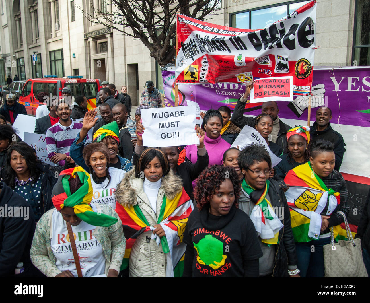 Londres, Royaume-Uni. 21 Février, 2015. Les activistes de l'extérieur de l'Ambassade du Zimbabwe dansent et chantent pour protester contre Mugabe pour son 91e anniversaire. Credit : Pete Maclaine/Alamy Live News Banque D'Images