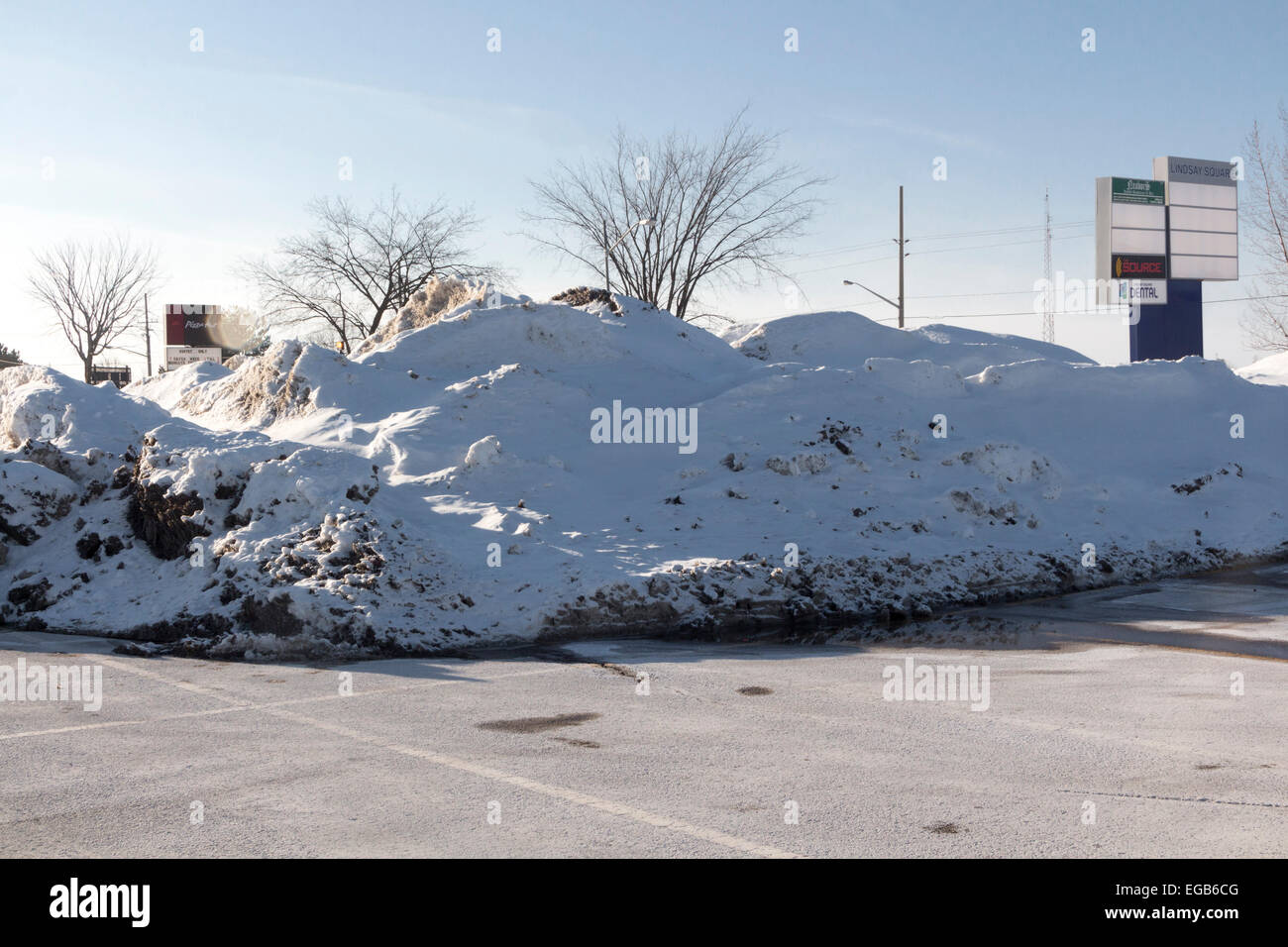 Grand monticule de neige labourée au parking de centre commercial à Lindsay, Ontario Canada Banque D'Images