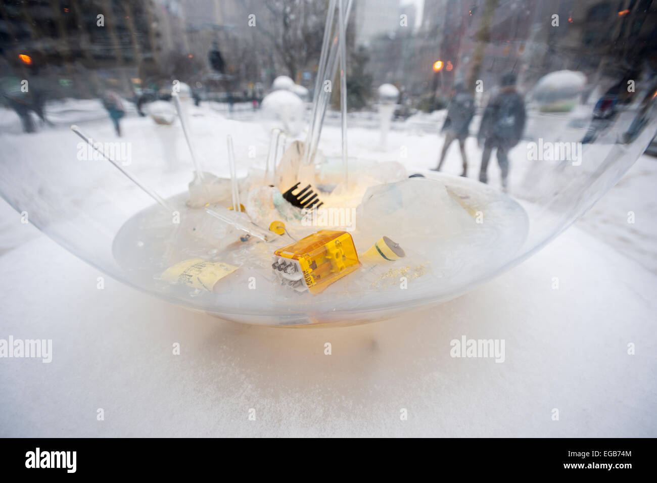 Les visiteurs au Madison Square Park de New York vue 'Gazing Globes" par l'artiste Paula Hayes dans la neige le samedi 21 février, 2015. Les globes qui rappelle de l'inversion de boules à neige, avec la neige à l'extérieur, sont des terrariums remplis de vestiges de la culture contemporaine, des objets trouvés, qui comprennent les amarres avec la technologie des matériaux végétaux et des cristaux. Une tempête hivernale hits New York du dépôt de jusqu'à quatre pouces de neige, couvrant les monticules de glace sale. (© Richard B. Levine) Banque D'Images