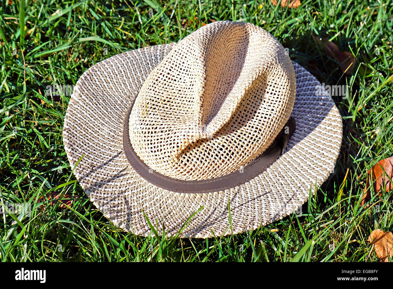 Un chapeau de paille vieux Mans allongé dans l'herbe. Banque D'Images